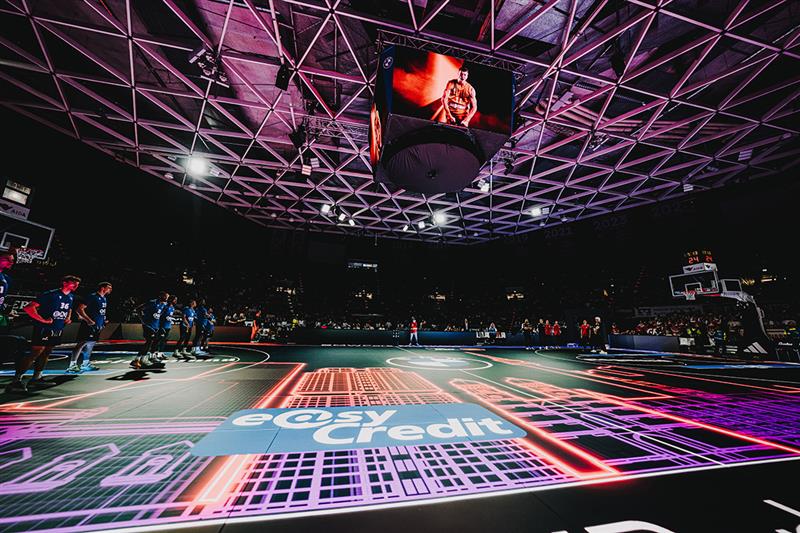 Aufnahme einer Arena für die Basketball Bundesliga.  Lichter in verschiedenen Farben leuchten. Auf dem Boden ist das easyCredit Logo zu sehen.