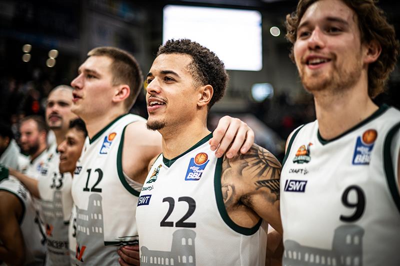Team aus der BBL (Basketball Bundesliga) stehen Arm in Arm zusammen