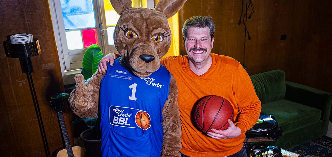 Elli-Hoop-Siggi Bild mit BBL-Maskottchen und Siggi, der einen Basketball in der Hand hält.