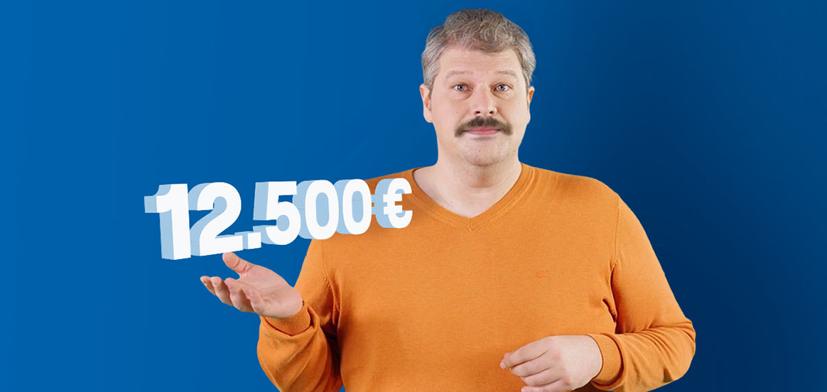 Siggi steht in einem orangenem Pullover vor einer blauen Wand. Der Betrag 12.500€ schwebt über seiner Hand.