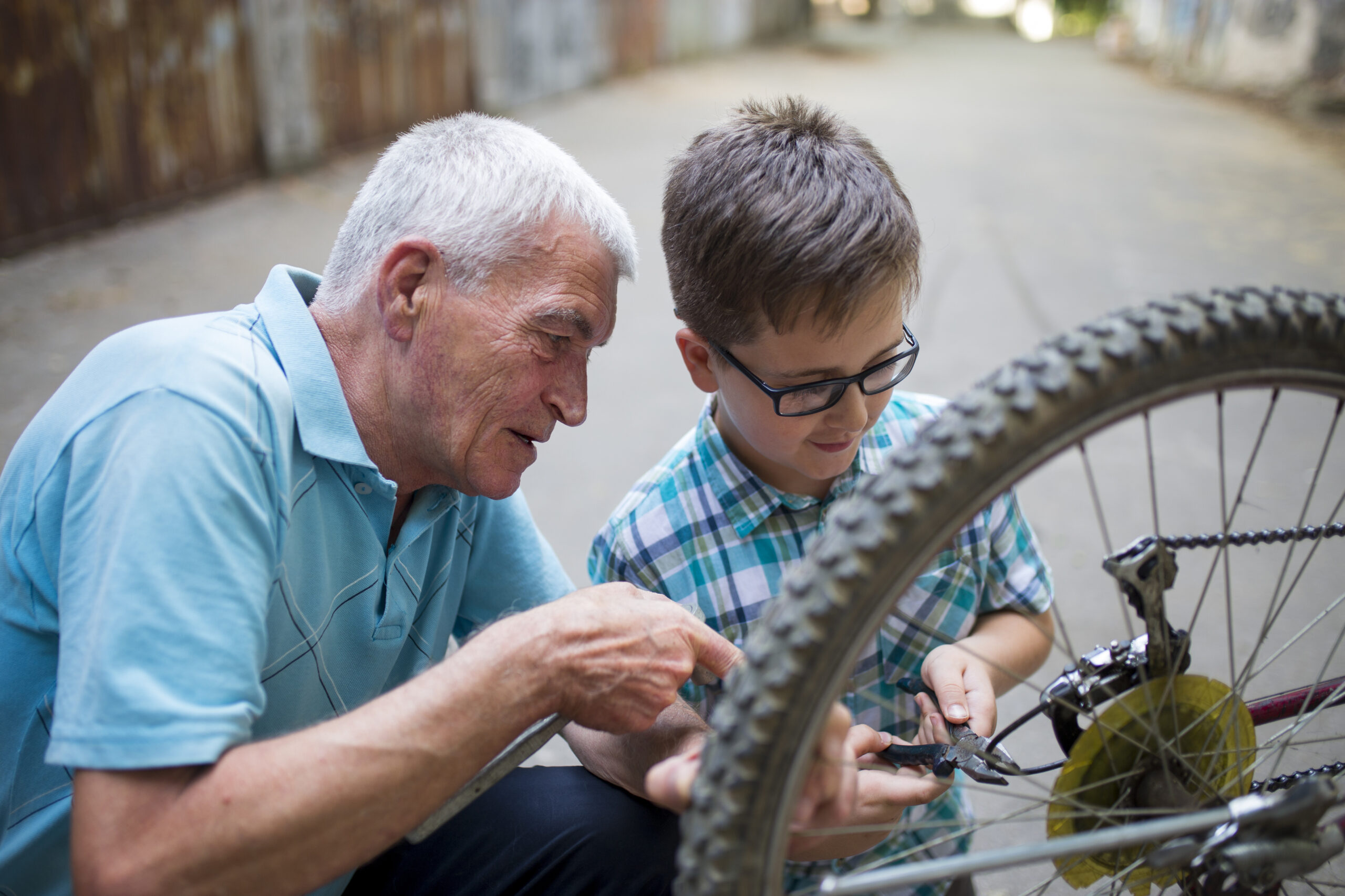 Älterer Mann erklärt Enkel Fahrradreparatur.
