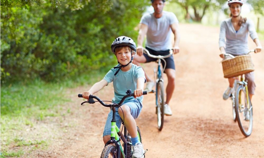 Glückliche Eltern und Kind fahren gemeinsam Fahrrad