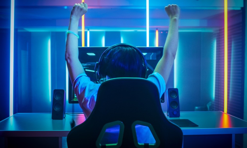 E-Gamer hält seine Hände freudig hoch