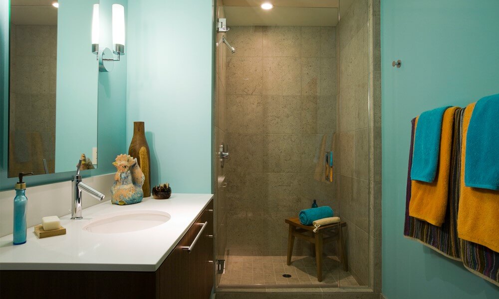 Ein Badezimmer mit Waschbecken und Dusche und auffälliger Wandfarbe.