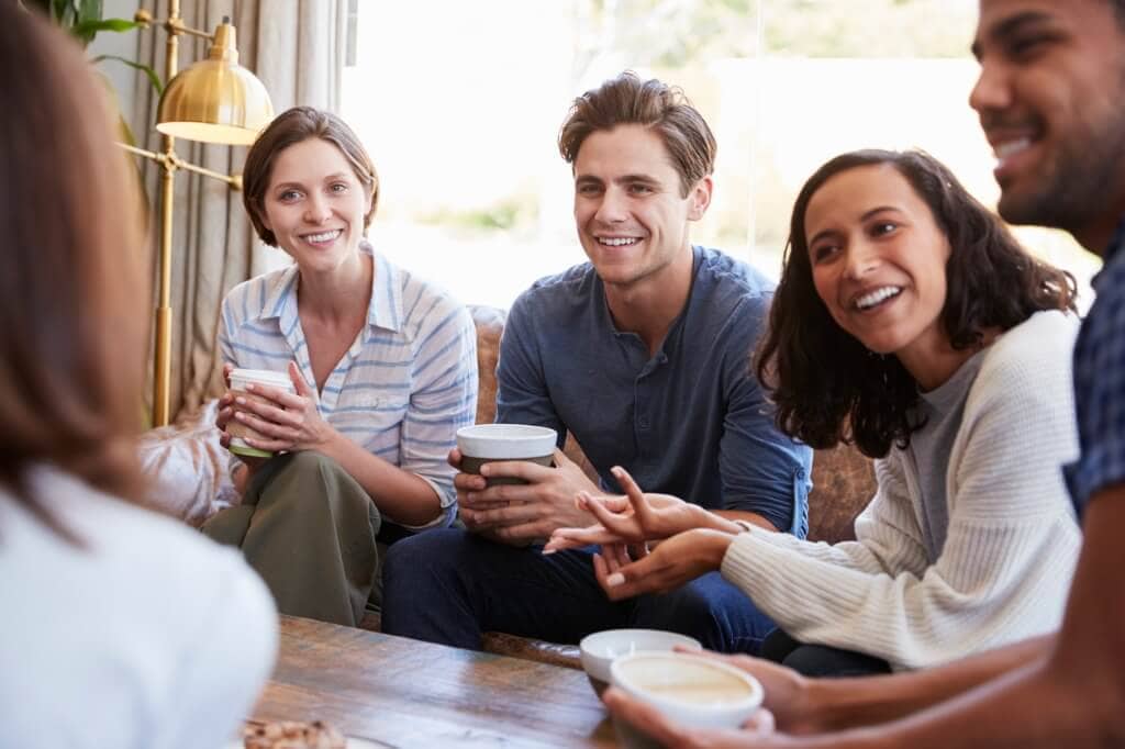 friends-relaxing-around-a-table-at-a-coffee-shop-close-up-picture-id1014257184 (2)