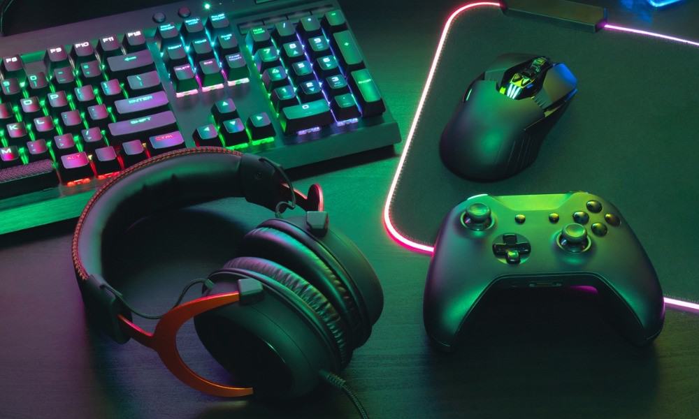 PC-Tastatur, Headset, Maus und Controller liegen auf Schreibtisch.